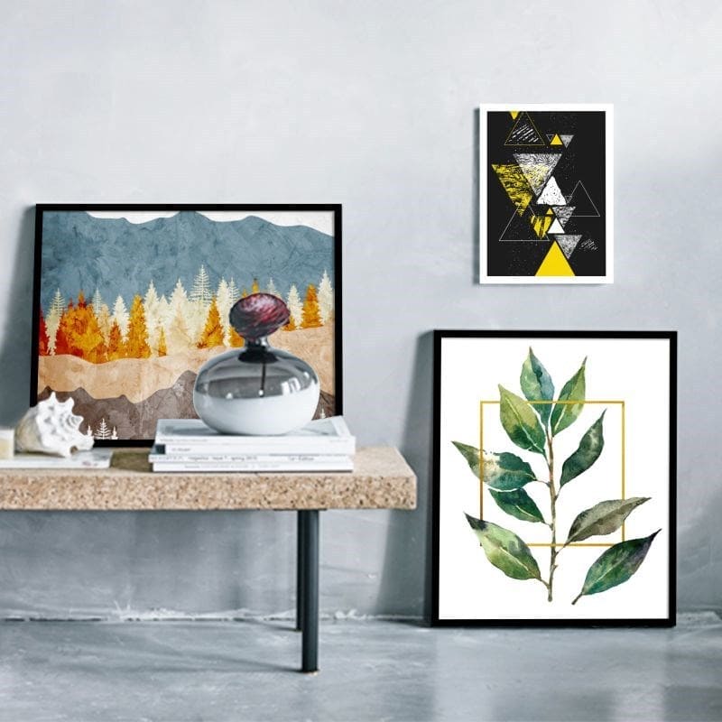 Framed artworks on a wall with a table displaying decorative items.