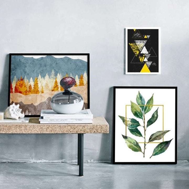 Framed artworks on a wall with a table displaying decorative items.