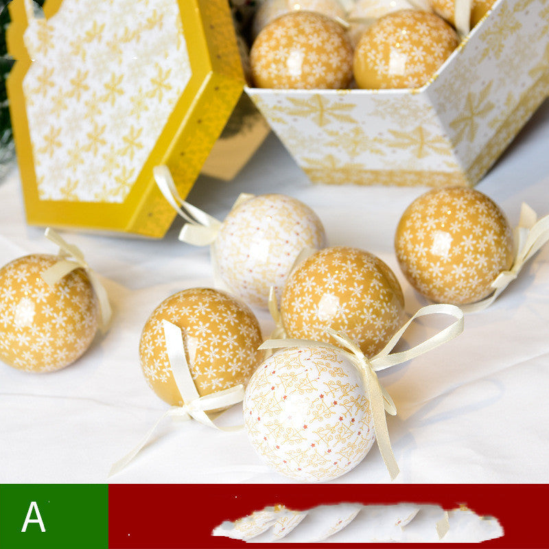 Decorative gold and white balls with ribbons on a white surface, with a yellow box in the background.
