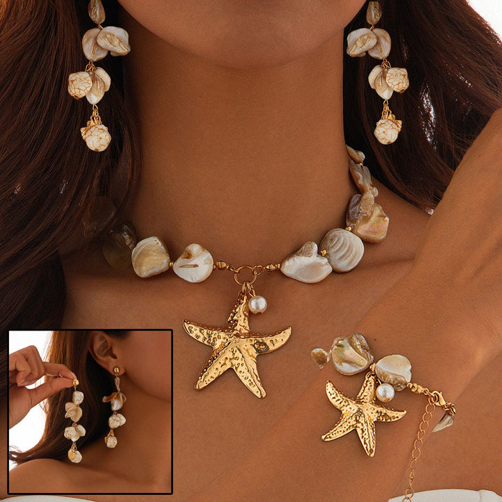 Starfish-themed jewelry set including necklace, earrings, and bracelet on a person against a neutral background.