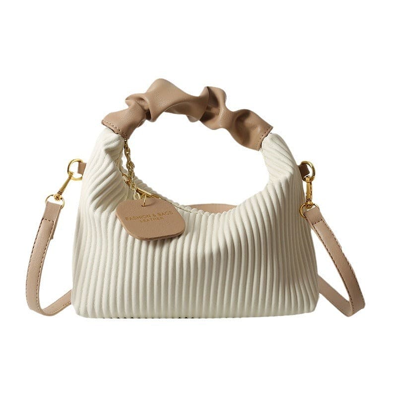 Beige handbag with ribbed texture and ruffled handle on a white background