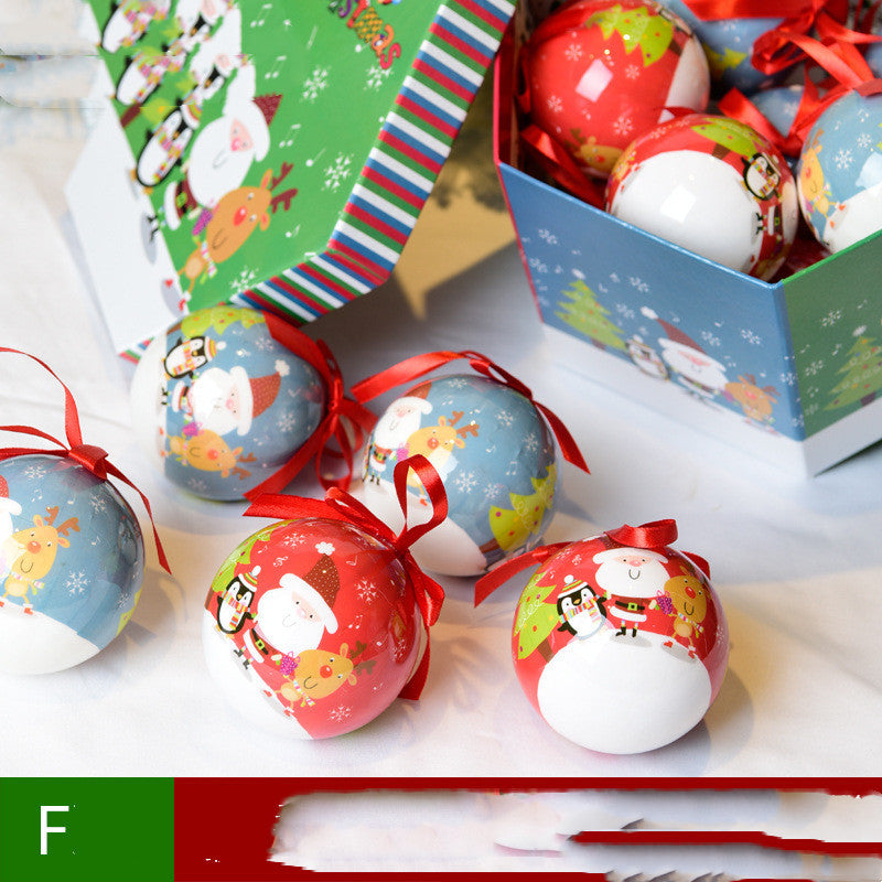 Decorative Christmas balls with Santa Claus design on a white surface, with gift boxes in the background.