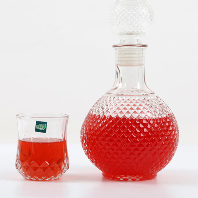 Home Bar Diamond Round Wine Decanter shown with a serving glass | Confetti Living