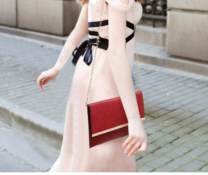 Woman holding a red clutch bag on a city street