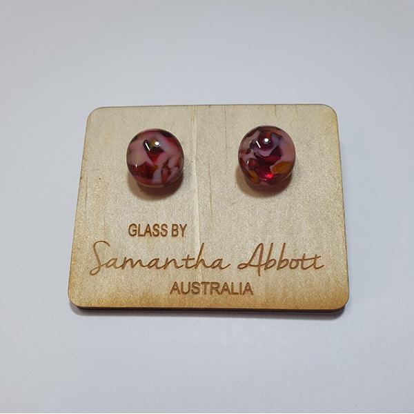 #7 Pink Swirls glass stud earrings shown on a natural plywood holder.