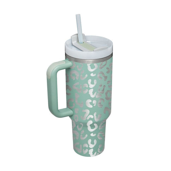 Mint green tumbler with leopard print pattern and handle on a white background