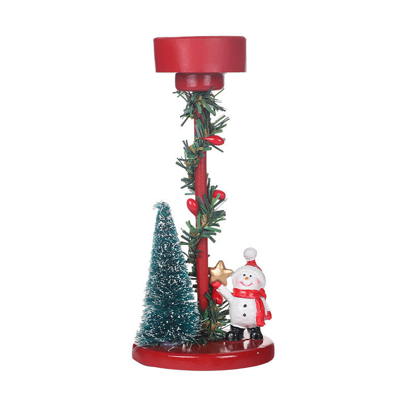 Decorative Christmas candle holder with red base, greenery, and festive figurines on a white background