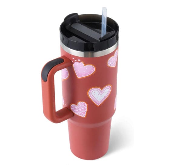 Red travel mug with heart patterns on a white background