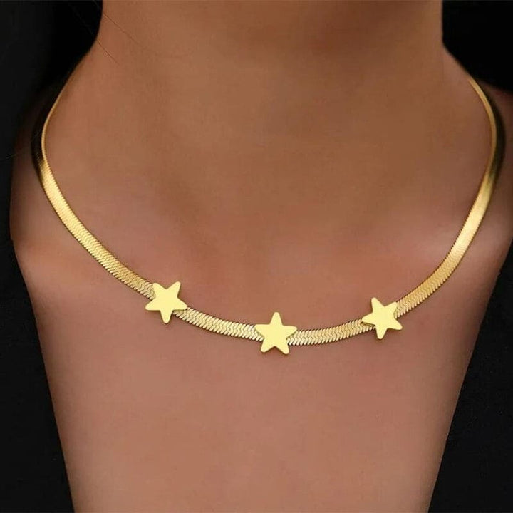 Gold necklace with star pendants on a black background