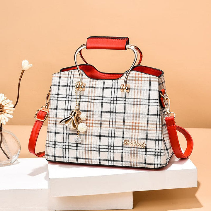 Plaid handbag with red handles and trim on a beige background