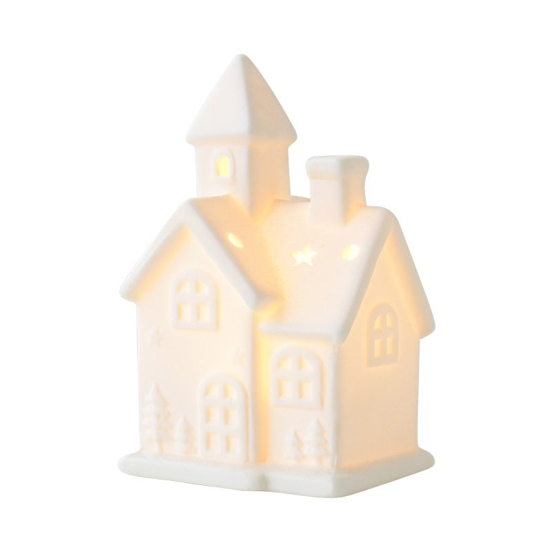 Ceramic house-shaped lantern with a warm glow on a white background