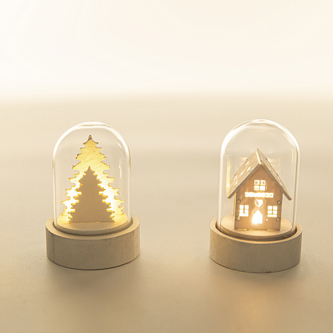 Two small decorative lights shaped like a Christmas tree and a house on a beige background