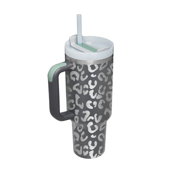 Gray tumbler with white leopard print pattern, gray handle, and straw on a white background