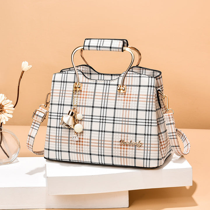 Plaid handbag with gold accents on a beige background